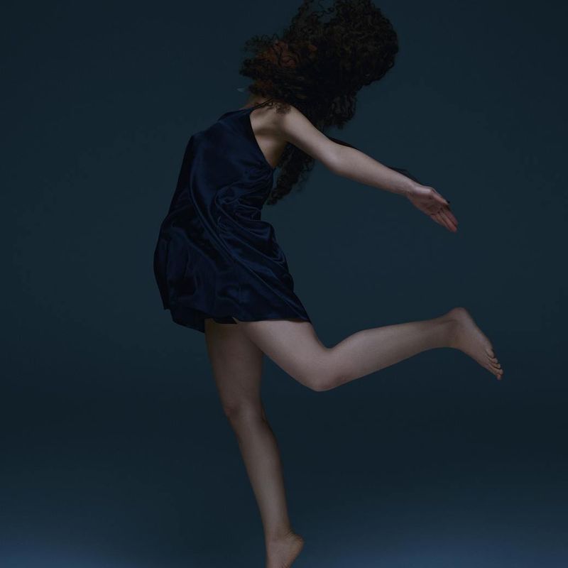 Person captured mid-movement in a spacious studio.